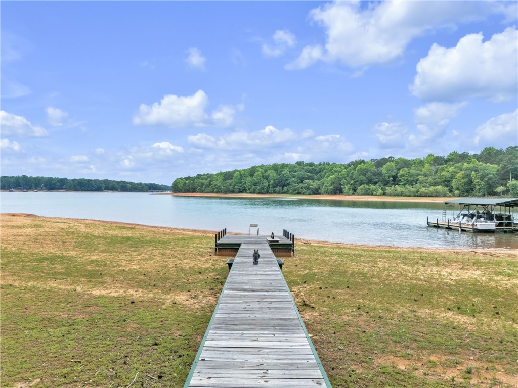 4416 Denver Cove Road Anderson, SC 29625 - Photo 27 of 31 A private dock extends into the shimmering lake, framed by lush tree-lined shores.