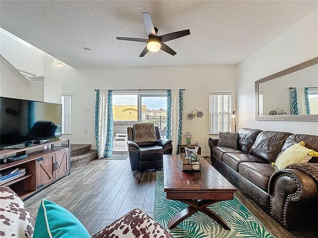 a living room with furniture ceiling fan and a flat screen tv