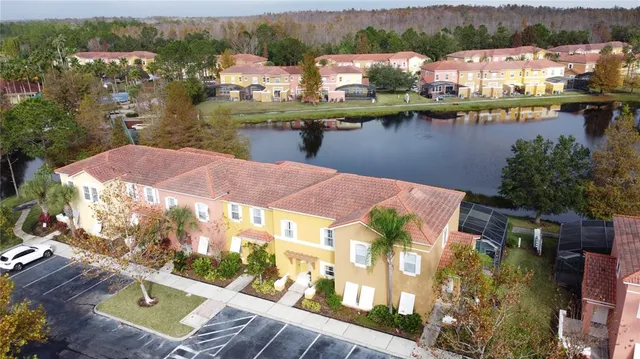 an aerial view of residential houses with outdoor space and lake view