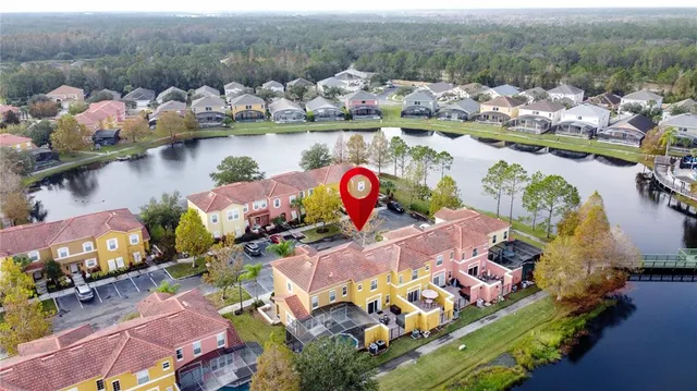 an aerial view of residential houses with outdoor space and lake view