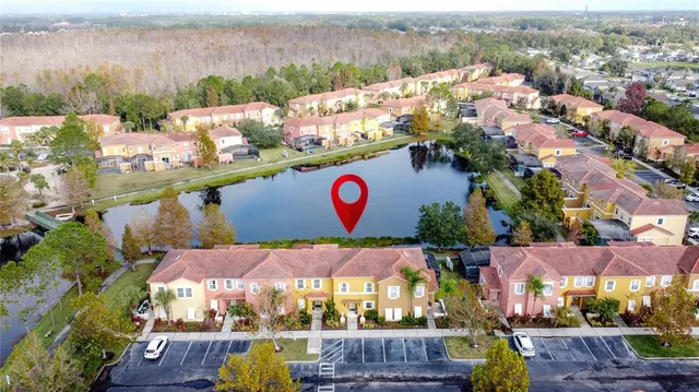 an aerial view of residential houses with outdoor space and lake view