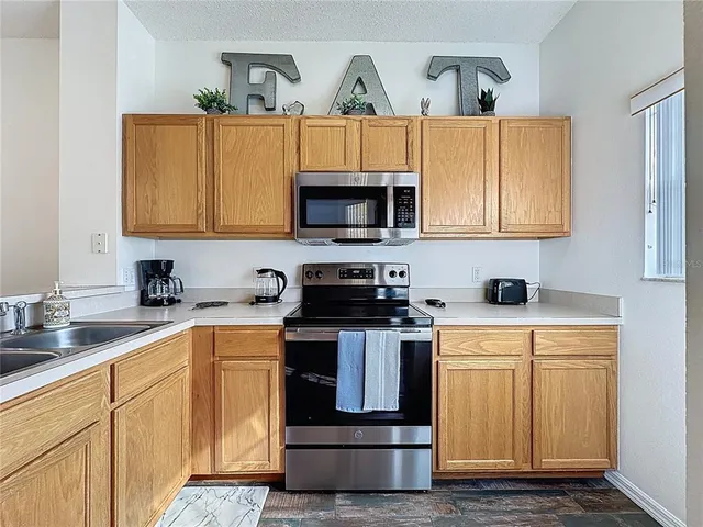 a kitchen with a sink stove and microwave