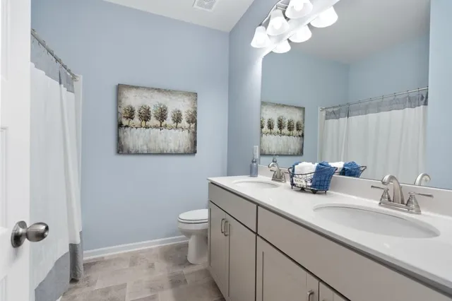 a bathroom with a toilet a sink and mirror