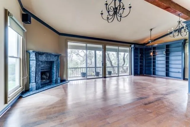 a view of an empty room with a fireplace and a window