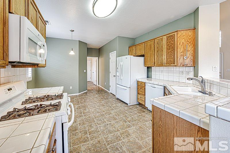 1137 Tule Drive Reno, NV 89521 - Photo 6 of 17 a kitchen with a stove a sink and a refrigerator