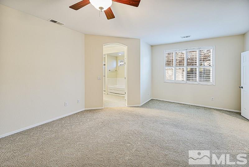 1137 Tule Drive Reno, NV 89521 - Photo 10 of 17 an empty room with chandelier fan and windows