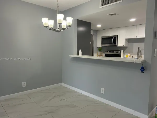 a view of kitchen with microwave and cabinets