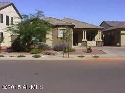 a front view of a house with a garden and tree