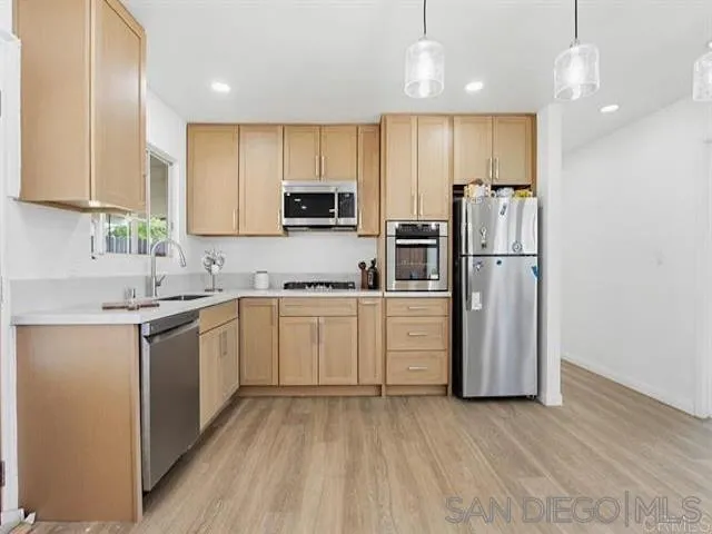 9462 Doheny Road Santee, CA 92071 - Photo 23 of 33 a kitchen with white cabinets and stainless steel appliances