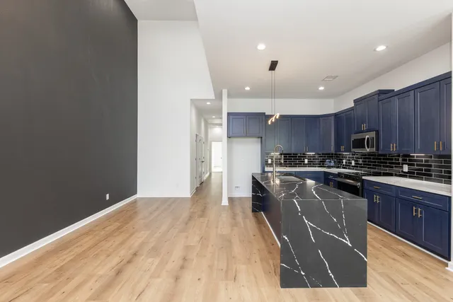 a kitchen with stainless steel appliances granite countertop a stove a sink and a refrigerator