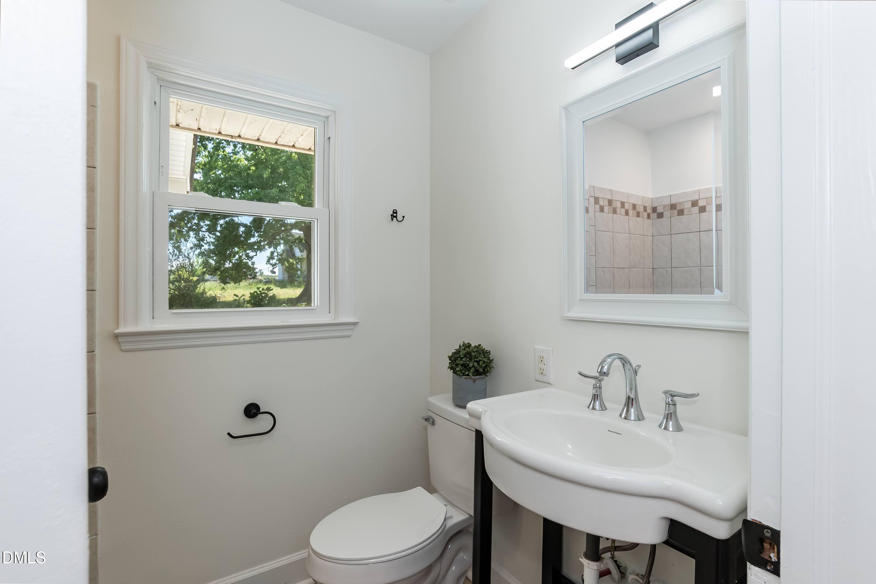 641 Rocky Ford Road Louisburg, NC 27549 - Photo 21 of 38 a bathroom with a toilet a sink and mirror