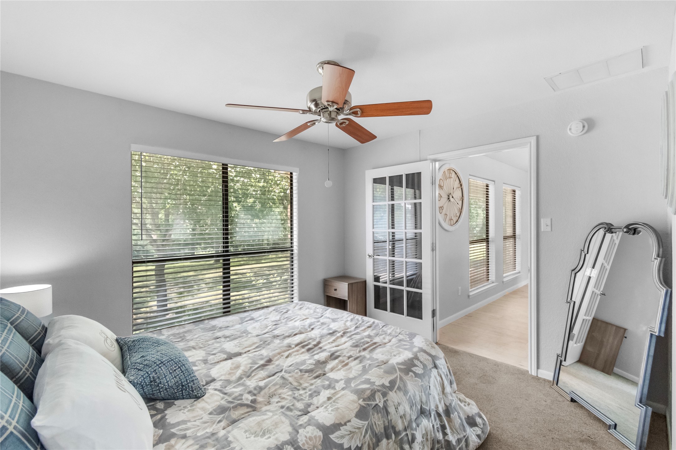 210 Teeoff, Unit B Horseshoe Bay, TX 78657 - Photo 21 of 38 Relax in this well-lit bedroom featuring a ceiling fan and large windows overlooking lush greenery.
