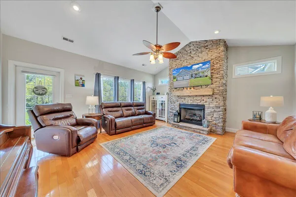 a living room with furniture a fireplace and a chandelier