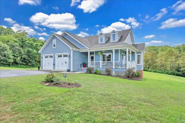 a view of pool with lawn chairs under an umbrella