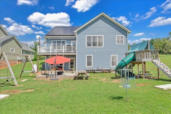 a view of a house with a yard and sitting area