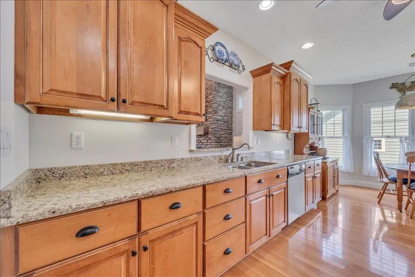 a kitchen with granite countertop a sink a window stainless steel appliances and cabinets