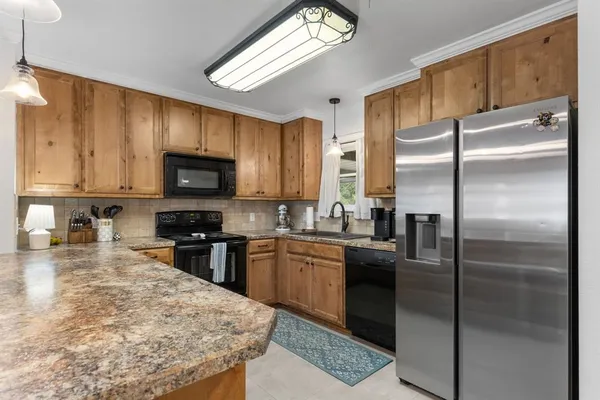 a kitchen with stainless steel appliances granite countertop a refrigerator a stove top oven a sink and dishwasher