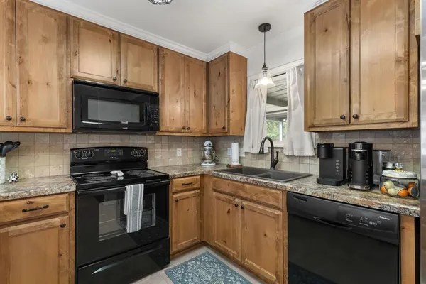 a kitchen with granite countertop a sink stainless steel appliances and cabinets