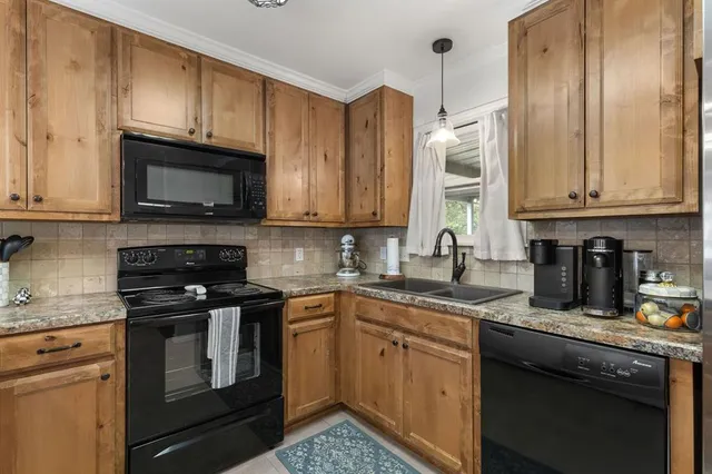 a kitchen with granite countertop a sink stainless steel appliances and cabinets