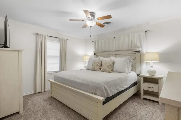 a bedroom with a bed and a ceiling fan