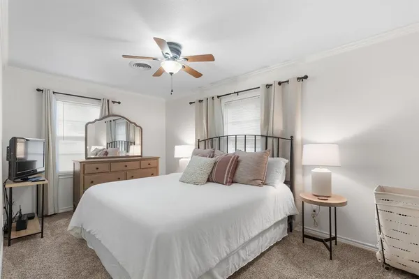 a bedroom with a bed a chandelier with a dresser and a chandelier