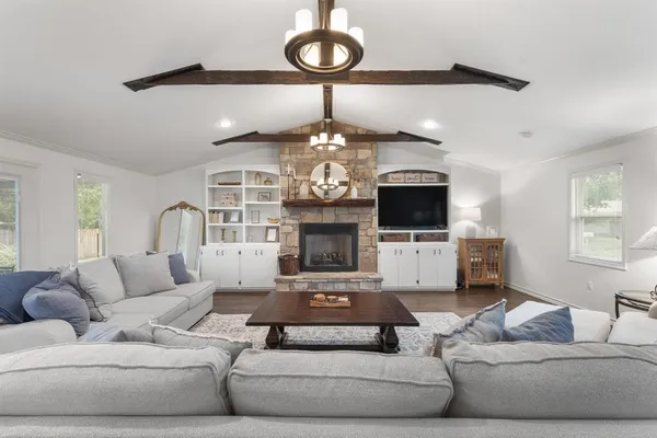a living room with furniture a fireplace and a chandelier