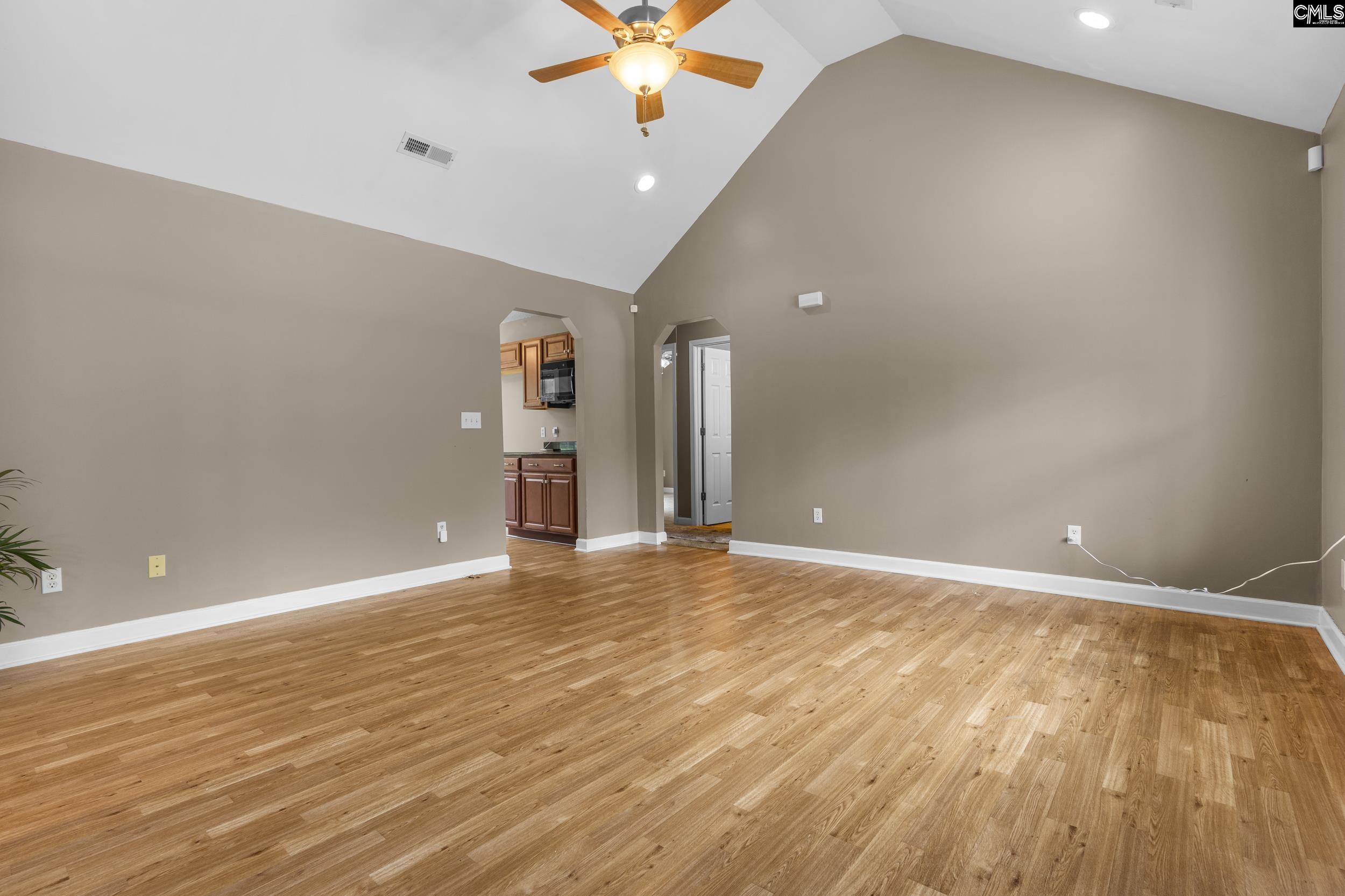 548 Eskie Dixon Road Elgin, SC 29045 - Photo 4 of 27 an empty room with wooden floor and a ceiling fan