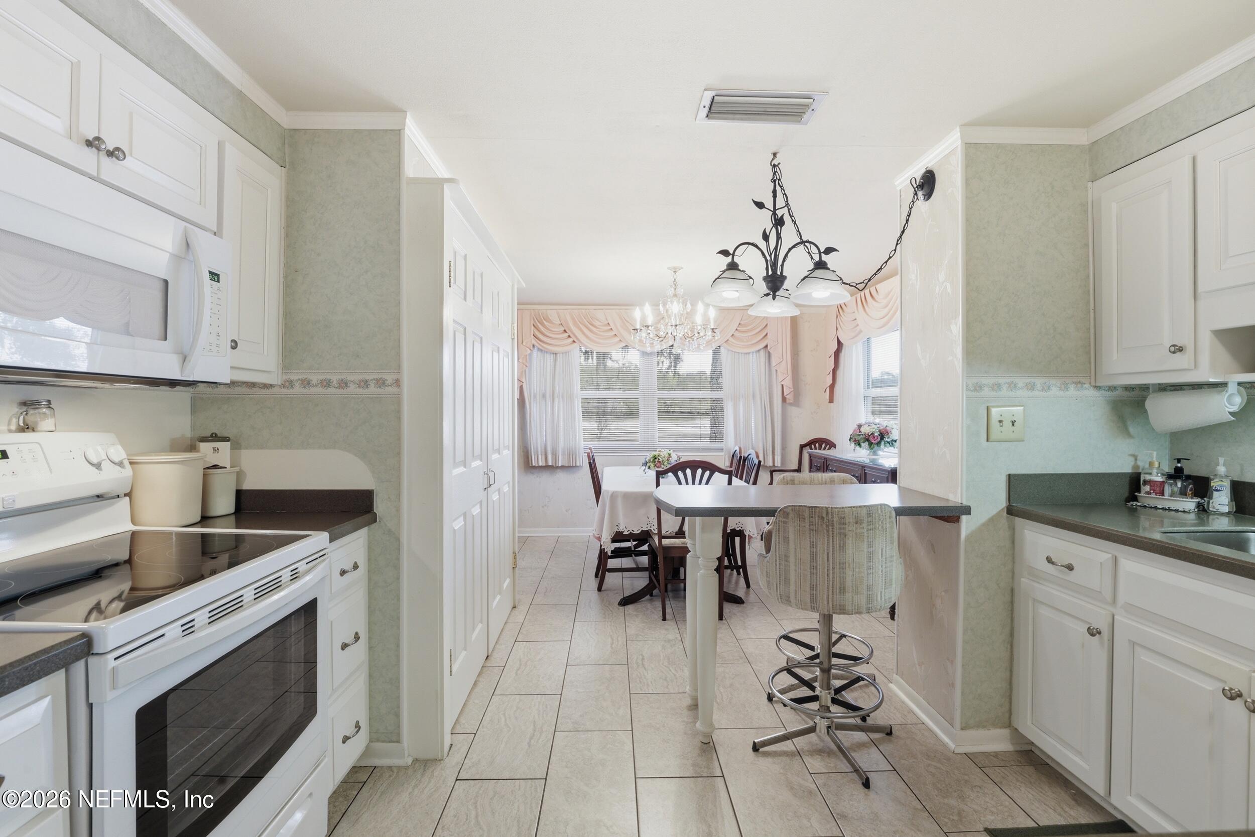 295 Northwest Berea Avenue Keystone Heights, FL 32656 - Photo 11 of 49 a kitchen with a sink stove and cabinets