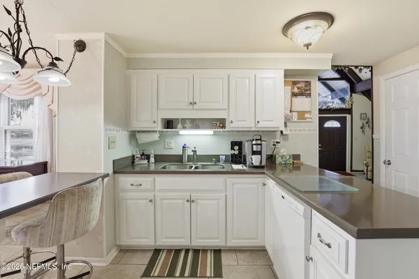 a kitchen with granite countertop a sink stove and cabinets