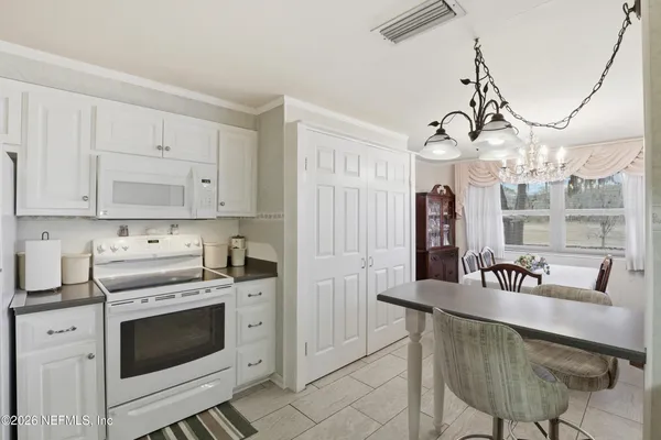 a kitchen with granite countertop white cabinets and stainless steel appliances