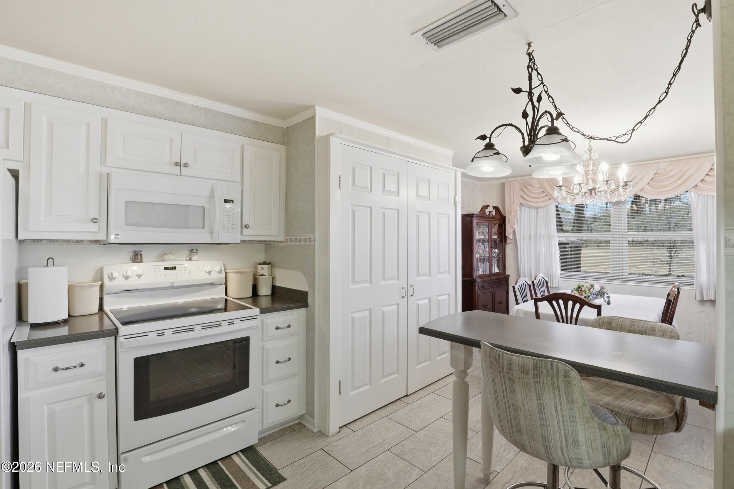 295 Northwest Berea Avenue Keystone Heights, FL 32656 - Photo 15 of 49 a kitchen with granite countertop white cabinets and stainless steel appliances