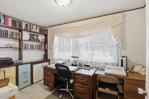 a view of a workspace with furniture and a window