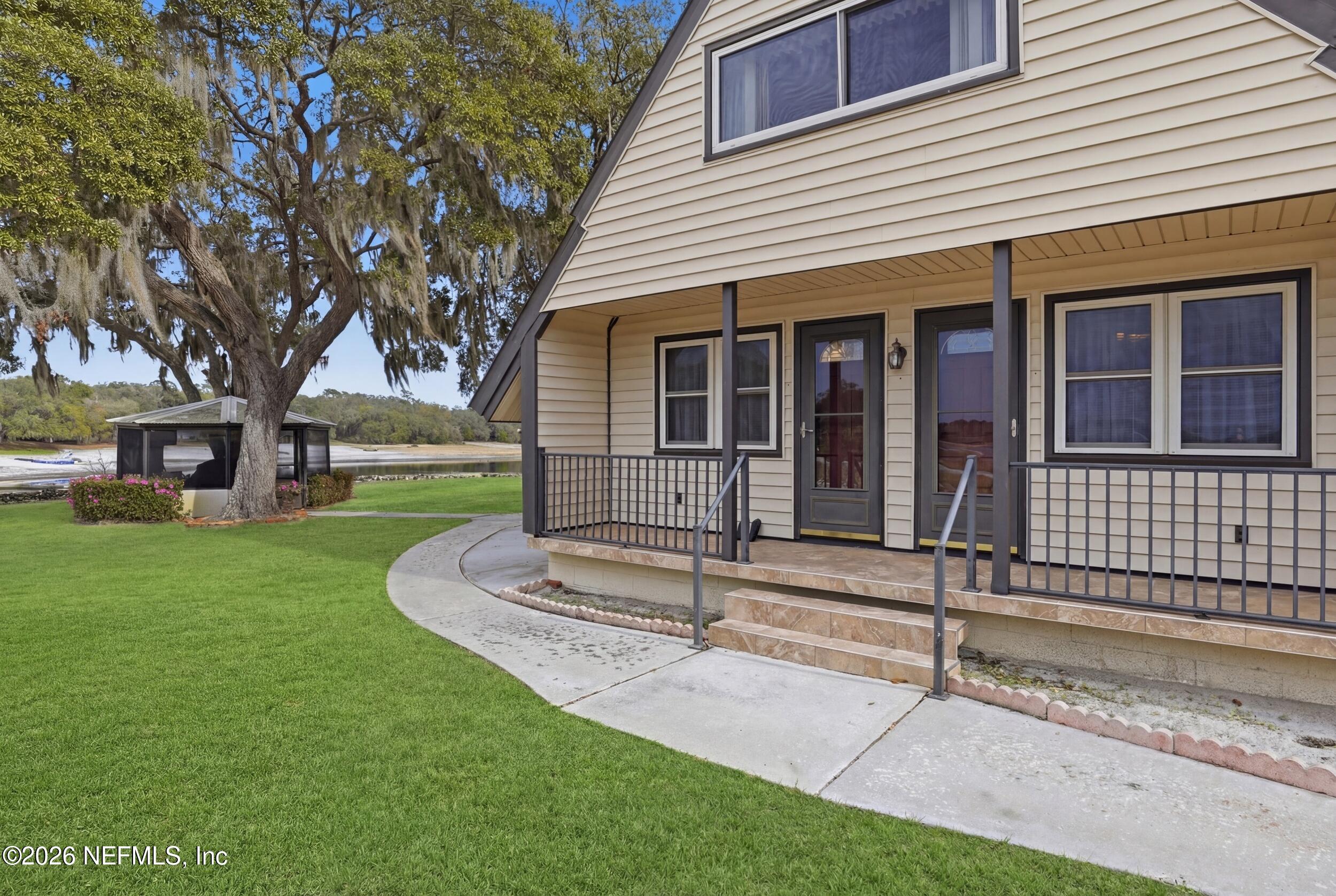 295 Northwest Berea Avenue Keystone Heights, FL 32656 - Photo 38 of 49 a front view of a house with a garden and trees