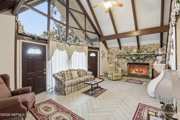 a living room with furniture a fireplace and a floor to ceiling window