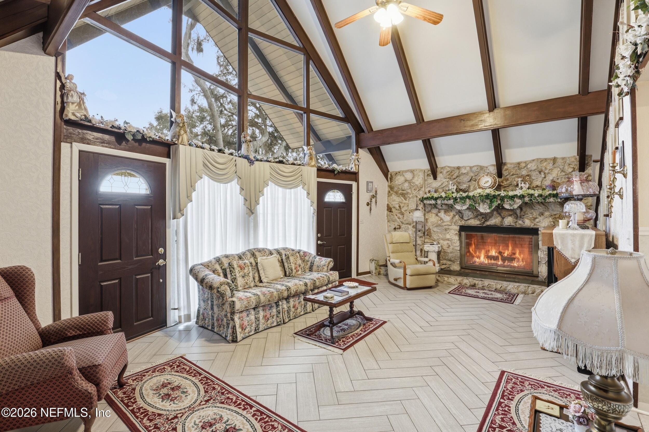 295 Northwest Berea Avenue Keystone Heights, FL 32656 - Photo 6 of 49 a living room with furniture a fireplace and a floor to ceiling window