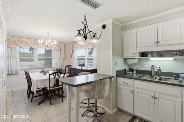 a kitchen with kitchen island granite countertop a sink a center island a dining table and chairs