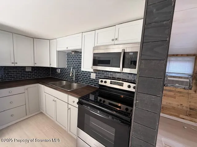 a kitchen with appliances a sink and cabinets