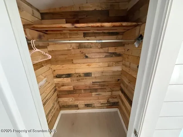a view of walk in closet with empty racks