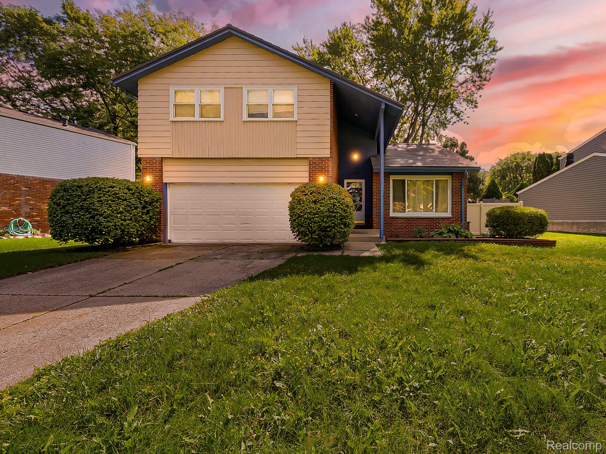 42195 Park Ridge Road Novi, MI 48375 - Photo 1 of 52 Two-story home featuring a combination of brick and siding, an attached garage, a paved driveway, and manicured shrubbery