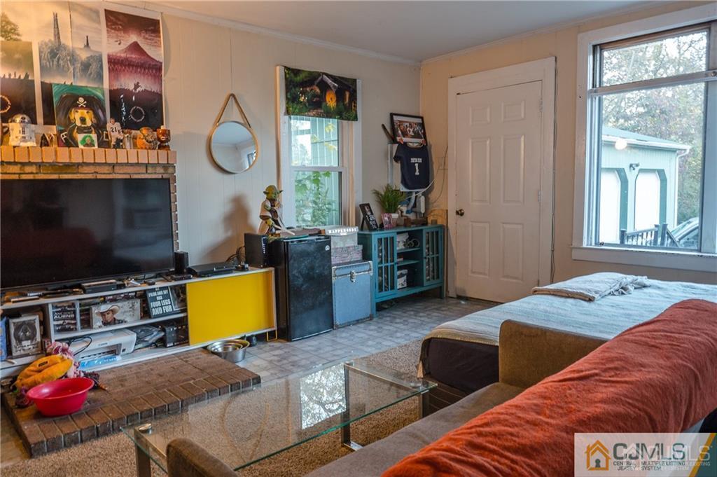 302 Schoolhouse Road, Unit B Monroe Township, NJ 08831 - Photo 5 of 8 a bedroom with furniture and a flat screen tv