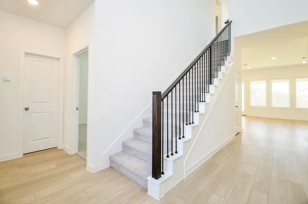 a view of a hallway with wooden floor and staircase