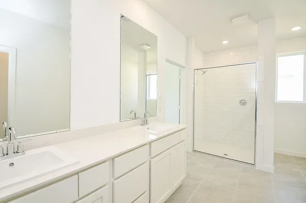 a bathroom with a double vanity sink mirror and shower