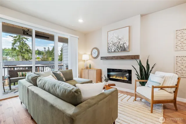 a living room with furniture a fireplace and a large window