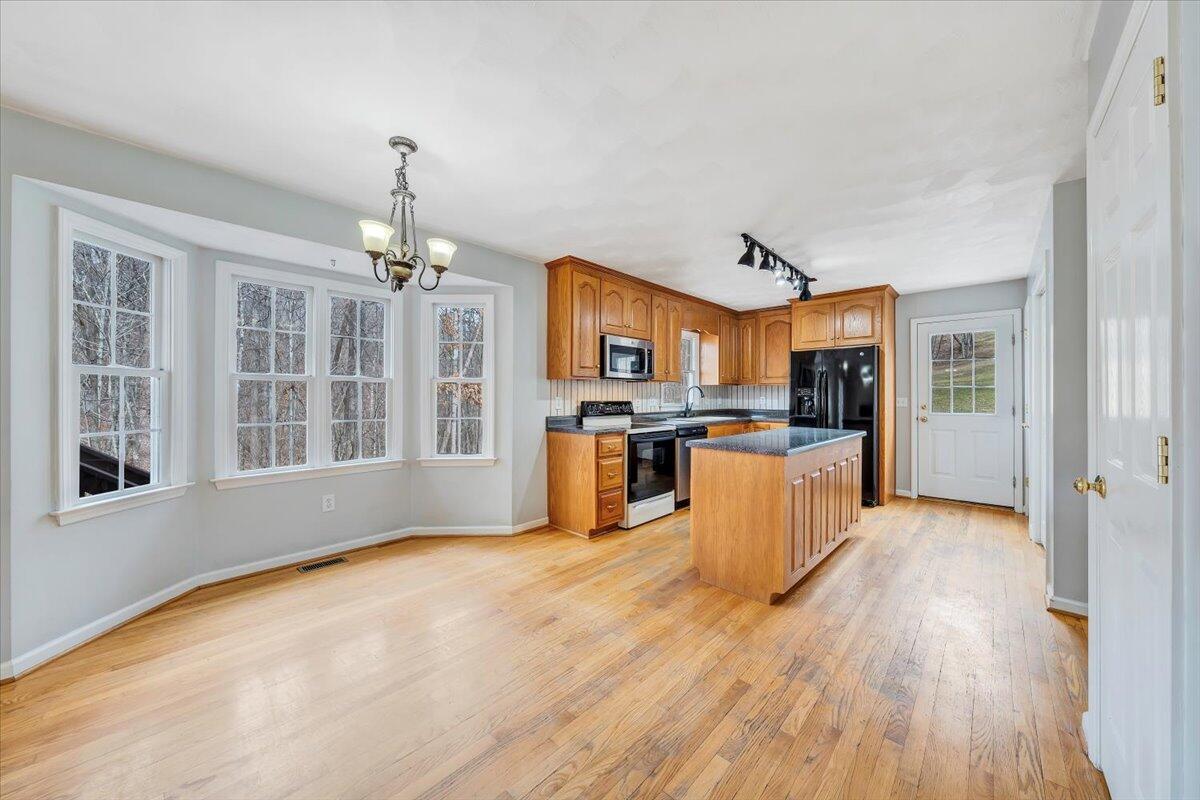 1063 Archway Road Blue Ridge, VA 24064 - Photo 12 of 46 a view of kitchen with stainless steel appliances granite countertop a stove top oven a sink dishwasher a refrigerator and cabinets with wooden floor