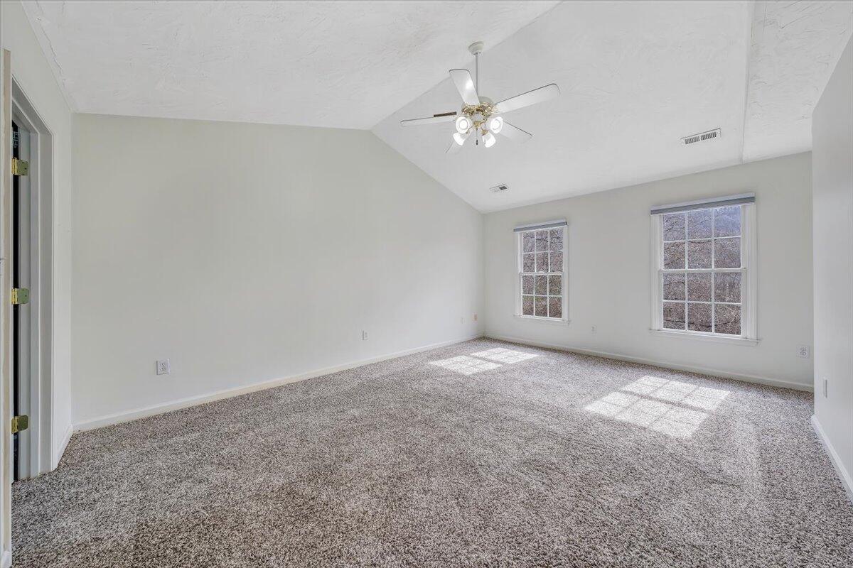 1063 Archway Road Blue Ridge, VA 24064 - Photo 20 of 46 an empty room with windows and chandelier fan