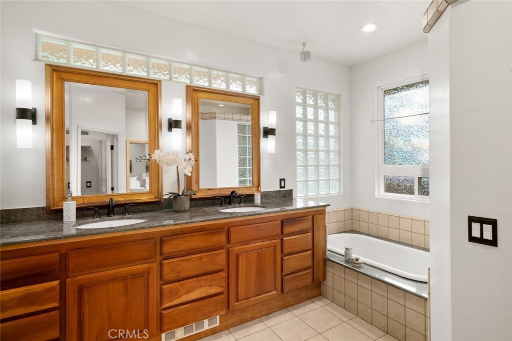 5982 Violeta Avenue Atascadero, CA 93422 - Photo 25 of 75 a bathroom with a granite countertop double vanity sink a mirror and a bathtub