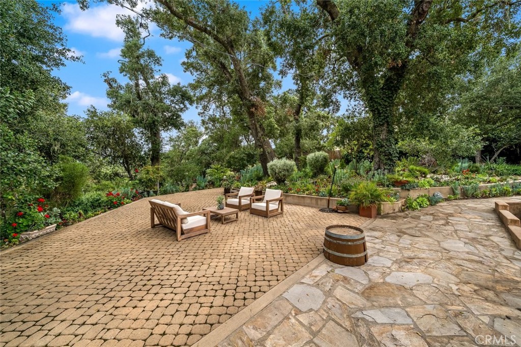 5982 Violeta Avenue Atascadero, CA 93422 - Photo 37 of 75 a view of a backyard with table and chairs potted plants and large trees