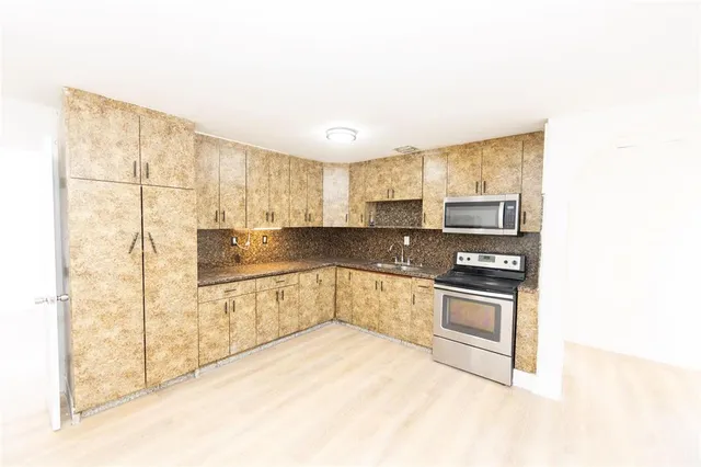 a kitchen with stainless steel appliances granite countertop a stove and a refrigerator