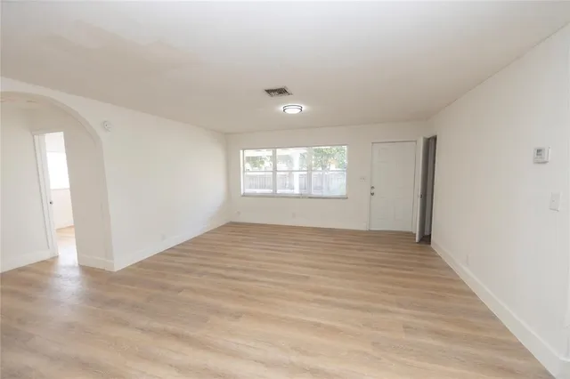 wooden floor in an empty room with a window