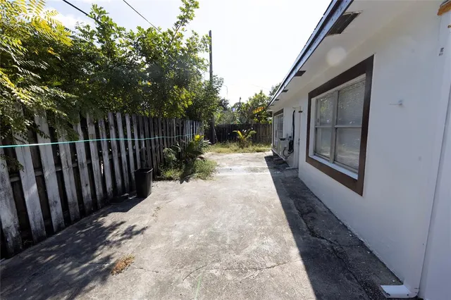 a view of a pathway of a house with wooden fence